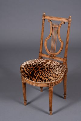 an image of a leopard print chair with a wooden frame and wooden legs