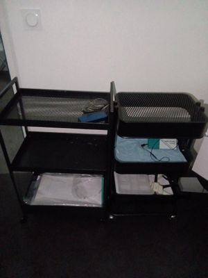 une étagère noire avec un lit et une chaise dans un coin