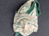 a green and white mask with a green ribbon on it