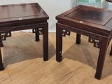 une paire de tables d'appoint de style asiatique posées sur un parquet dans un salon