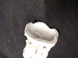 a small white vase with a flower inside of it