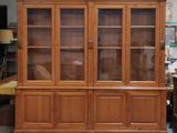 a large wooden cabinet with glass doors in a room