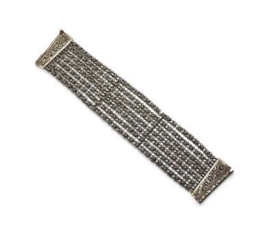 a close up of a silver bracelet on a white background