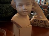 a statue of a child sitting on a table next to a box