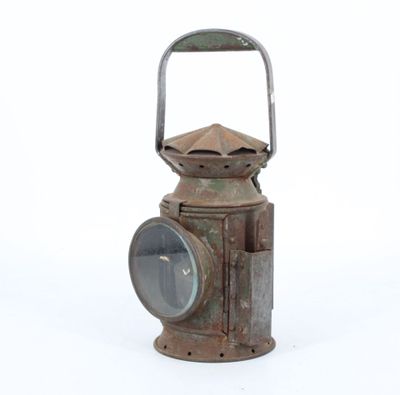 an old rusty lantern sitting on a white surface