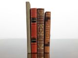 two old books sitting on top of a table next to each other