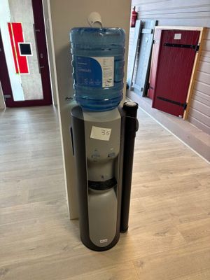 a water dispenser in the corner of a room