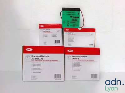 trois boîtes de piles empilées les unes sur les autres sur une surface blanche