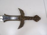 a metal sword with a bird on it on a table