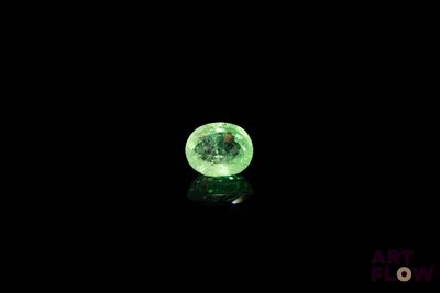 a close up of a glowing green ball on a black surface