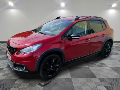 a red car is parked in a room with a checkered floor