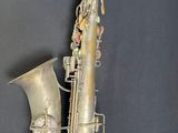 an old saxophone that is sitting on a black surface