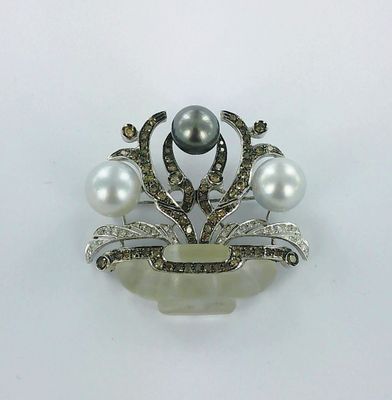une broche en perles et diamants sur fond blanc