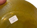 a person holding a yellow vase with a sticker on it