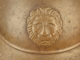 a statue of a lion head on top of a vase