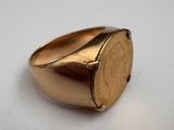 an image of a gold signet ring on a white surface