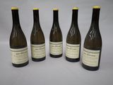 four bottles of wine are lined up on a table