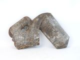 two pieces of old metal are sitting on a white surface