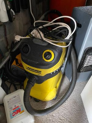 un aspirateur jaune et noir posé par terre à côté d'autres objets