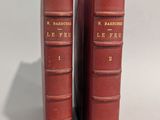 deux livres rouges posés l'un sur l'autre sur une table