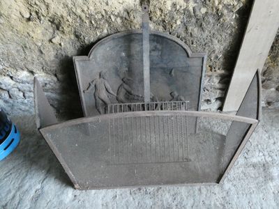 une vieille cheminée surmontée d'une cage à oiseaux