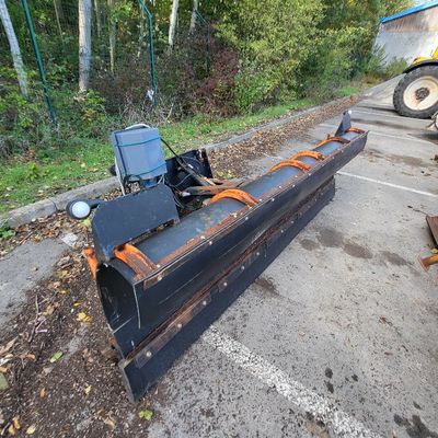 an image of a snow plow parked in a parking lot