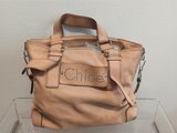 michael korsh leather handbag with studded logo on the front
