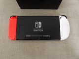 a red and white nintendo switch next to a black box