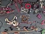 many different types of necklaces and bracelets laid out on a table