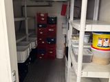 a small room with shelves and bins in it