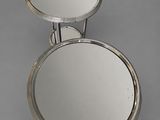 pair of silver plated mirrors on stand on grey background