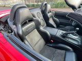 the interior of a red sports car with black leather seats