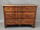 une commode en bois avec des poignées et des tiroirs ouvragés