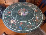 une table en marbre sur laquelle sont disposées des fleurs, dans un salon