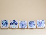 quatre petites cartes ornées de motifs bleus et verts, posées sur une table