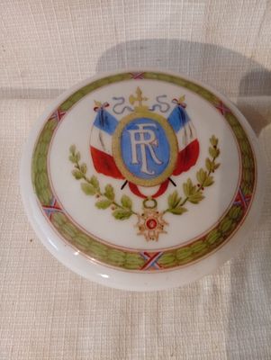 une assiette blanche ornée d'un emblème bleu et or