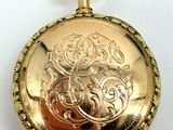 a gold pocket watch on a white surface