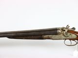 an old gun that is on display on a white surface