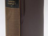 an old book sitting on top of a table next to a yellow ribbon