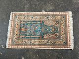 un tapis posé à même le sol, sur fond bleu