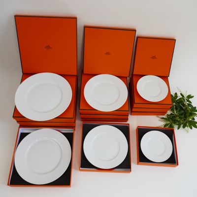 four white plates in orange boxes with a plant on top of them