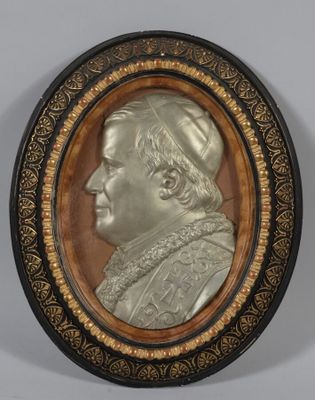 un gros plan sur une plaque métallique représentant le portrait d'un homme