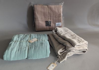 two blankets and a blanket on a table with a tag on it