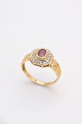 a close up of a gold ring with a ruby stone in the center