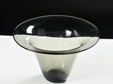 a glass vase with a black rim sitting on a white table