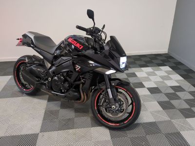 une moto noire garée sur un sol à damier