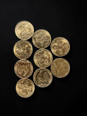 a close up of a pile of gold coins on a black surface