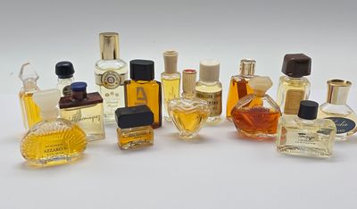 de nombreux flacons de parfum de toutes sortes posés sur une surface blanche