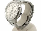 a silver watch on a stand with a white background