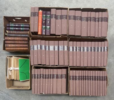 des cartons de livres empilés les uns sur les autres sur un sol en béton